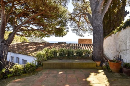 Cour intérieure avec arbres matures et toiture en terre cuite de l'hôtel Finques Garcia Enrich à Palafrugell