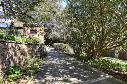 Allée bordée d'arbres de l'hôtel Finques Garcia Enrich à Palafrugell, Espagne avec murs en pierre et architecture historique