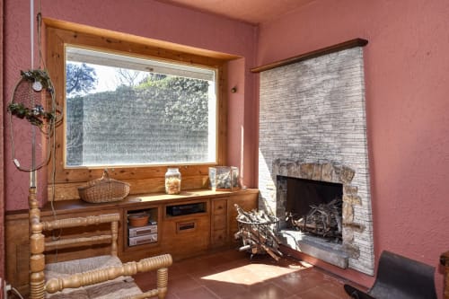 Chambre rustique à Finques Garcia Enrich, Palafrugell avec cheminée, mobilier en bois et grande fenêtre