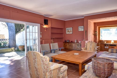 Spacieux séjour de l'hôtel Finques Garcia Enrich à Palafrugell avec murs en terre cuite, mobilier confortable et table en bois