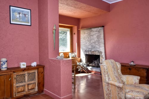 Salon rustique rose avec cheminée et mobilier en bois à Finques Garcia Enrich, Palafrugell