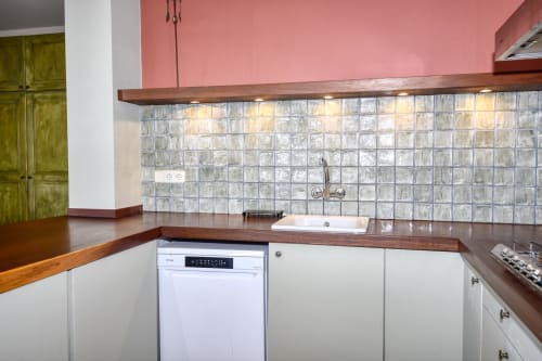 Cuisine moderne de l'hôtel Finques Garcia Enrich à Palafrugell avec armoires blanches, plans de travail en bois et crédence en carrelage verre