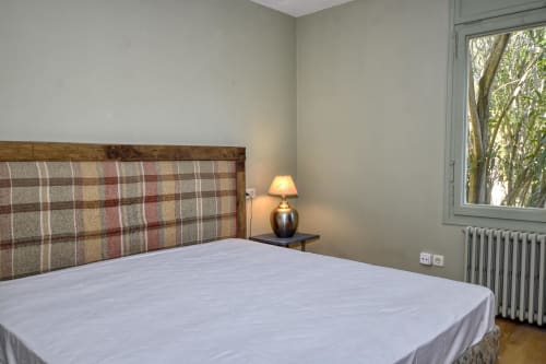 Chambre moderne aux Finques Garcia Enrich à Palafrugell avec tête de lit à carreaux, literie blanche et lumière naturelle