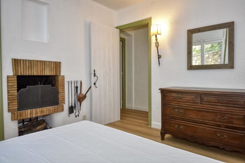 Chambre aux Finques Garcia Enrich à Palafrugell avec foyer, commode en bois et miroir