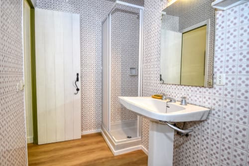 Salle de bains moderne à l'hôtel Finques Garcia Enrich à Palafrugell avec douche vitrée et lavabo blanc