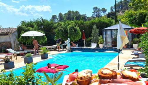 Journée ensoleillée à la piscine de La Bergerie Du Moulin, Taradeau avec des clients profitant de l'eau turquoise et des vues sur le jardin