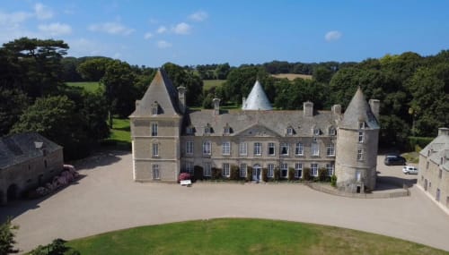 Château d'Alexis de Tocqueville, a grand stone manor with towers in Tocqueville, France surrounded by manicured grounds.