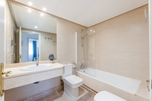 Modern bathroom in Marbella Home Rentals Puerto Banus apartment with vanity, toilet, bathtub and shower