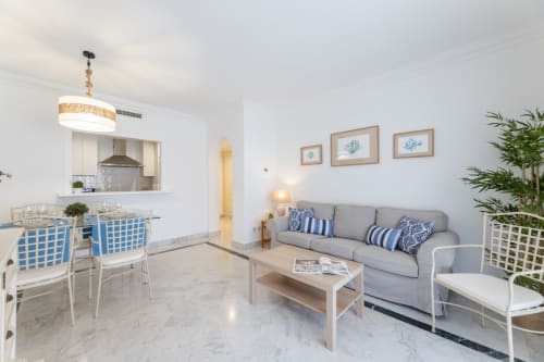 Modern 2-bedroom apartment in Puerto Banus, Marbella with open-plan living, gray sofa, and coastal-inspired decor