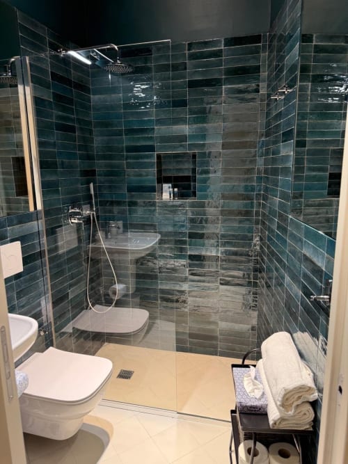 Bagno moderno a Tresette Porta Capuana a Napoli con piastrelle teal scuro, box doccia in vetro, wc bianco e riscaldato