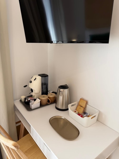 Angolo caffè con bollitore, macchina espresso e servizi presso il cottage Tresette Porta Capuana a Napoli, con TV