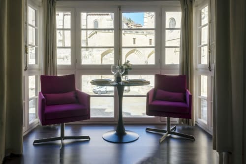 Sillones púrpuras con mesa redonda negra en apartamento moderno Cathedral Suite con vistas al emblemático Burgos