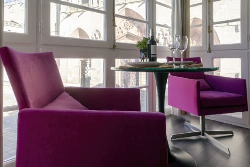 Sillas y mesa de diseño contemporáneo en color púrpura en la suite catedral con vistas al monumento de la catedral de Burgos