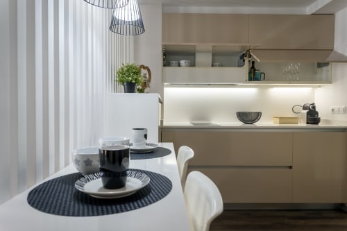 Cocina-comedor moderna en la Suite Cathedral del apartamento de Burgos con mesa de comedor, mobiliario contemporáneo y vistas a la ciudad