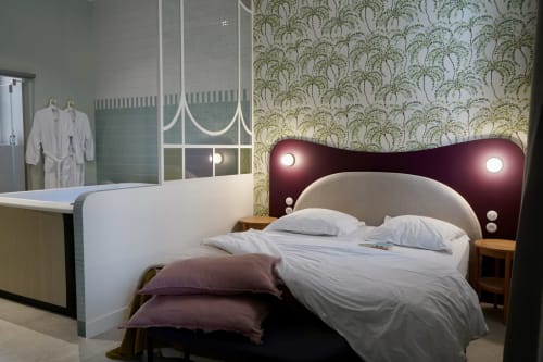 Chambre de charme à La Maison D'olivier avec lit élégant, papier peint motifs et éclairage ambiant à Mesnard La