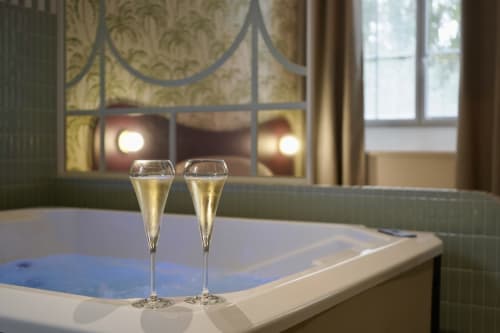 Deux flutes de champagne au bord du bain à remous de la Maison d'Olivier avec vue intérieure élégante