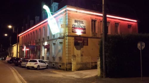 Façade illuminée du Hôtel de Champagne la nuit à Saint-Dizier, France avec enseigne de restaurant