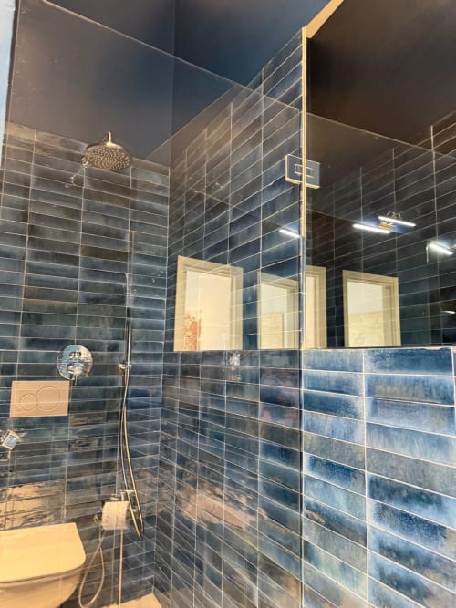 Moderno bagno presso Tresette Porta Capuana, Napoli con pareti in piastrelle blu, cabina doccia in vetro, soffione pioggia e