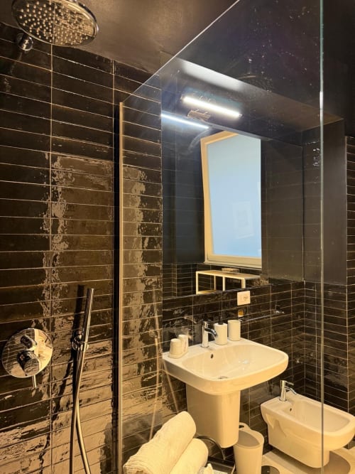Bagno moderno a Tresette Porta Capuana a Napoli con piastrelle nere, lavabo su colonna, bidet e doccia con
