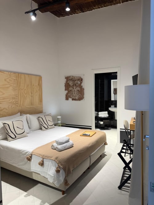 Camera moderna dell'hotel Tresette Porta Capuana a Napoli con testata in legno naturale, biancheria bianca, bagno en-suite e