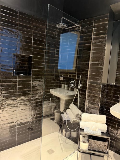 Moderno bagno a Tresette Porta Capuana Napoli con piastrelle nere, box doccia in vetro, lavabo su colonna e bianco