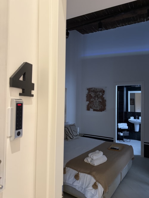 Camera 4 presso Tresette Porta Capuana a Napoli con letto, parete blu, tastierino digitale e ingresso bagno