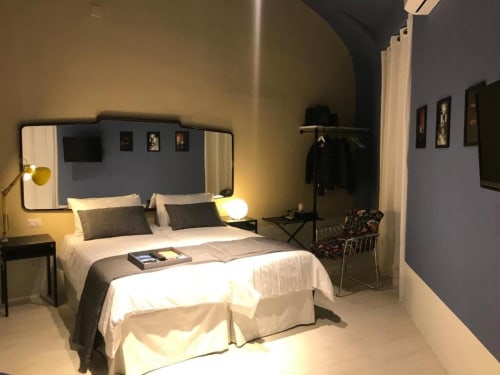Camera moderna dell'hotel Tresette Porta Capuana a Napoli con letto matrimoniale, testata a specchio e arredamenti contemporanei.