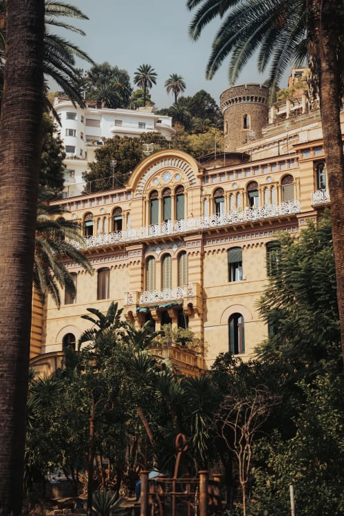 Lussuoso palazzo Tresette a Porta Capuana a Napoli con elegante facciata rigata, palme e torre storica