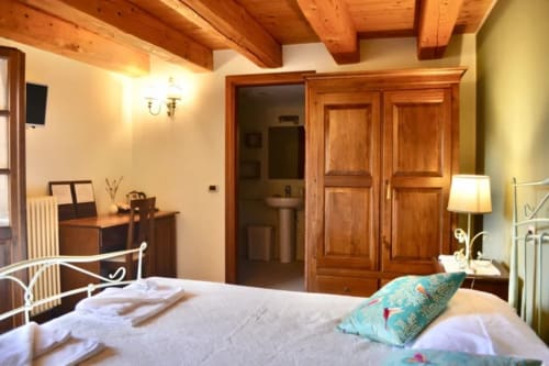 Camera Lavanda dell'Agriturismo Colle Mura a Gualdo Tadino con travi in legno e cuscino turchese