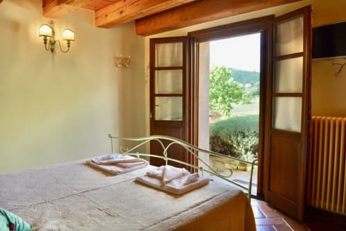 La camera Lavanda all'Agriturismo Colle Mura a Gualdo Tadino con vista sulla campagna dalle porte-finestre