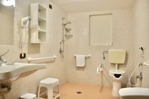 Accessible bathroom at Agriturismo Colle Mura in Gualdo Tadino with grab bars, accessible toilet, shower, and sink facilities