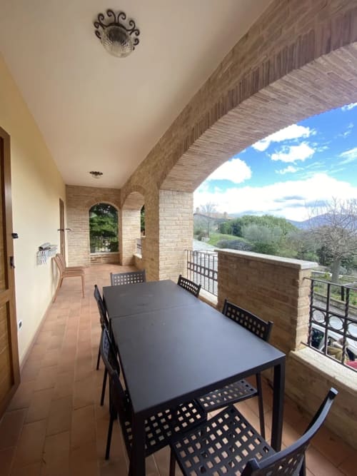 Terrazza coperta con zona ristorazione presso l'Agriturismo Colle Mura a Gualdo Tadino, con vista sulle montagne