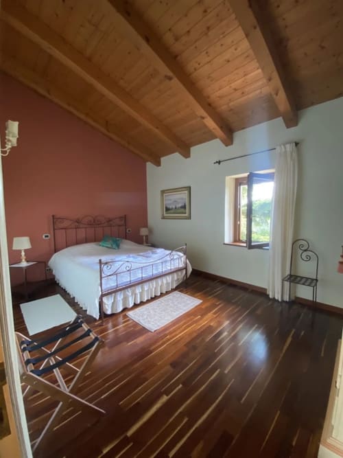 L'Artista bedroom at Agriturismo Colle Mura, Gualdo Tadino - spacious room with exposed beams, wrought iron bed, wooden