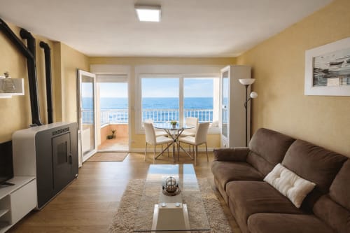 Albatros Dúplex en Baiona con vistas al mar, sofá marrón, comedor y balcón con vista al océano