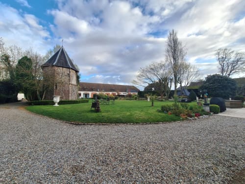 Cour de La Cour d'Hortense avec tour historique, pelouse soignée et espace détente à Sailly-Flibeaucourt