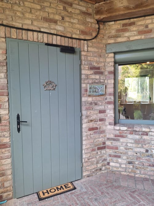Entrée de la chambre La Cour d'Hortense avec sa porte vert sage et façade en brique à Sailly-Flibeaucourt
