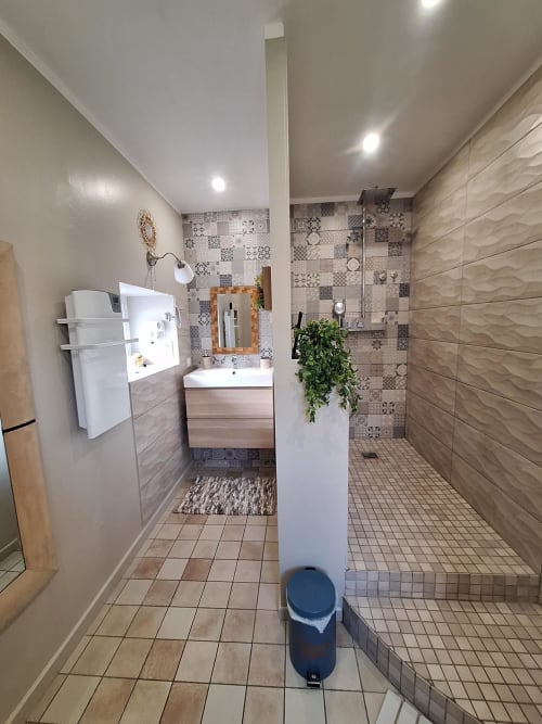 Salle de bain moderne à La Cour d'Hortense avec lavabo, douche, radiateur sèche-serviettes et carrelage à motifs