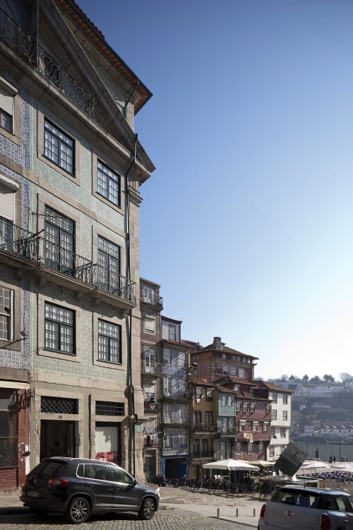 Rua histórica do Porto com edifícios coloridos, fachadas azuleijadas e vistas do rio no hotel PortoSense