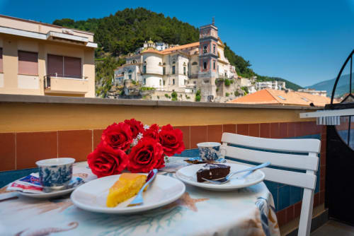 Cena in terrazza a Casa Mannini B&B a Maiori con rose rosse, pasticcini e vista del villaggio della Costiera Amalfitana