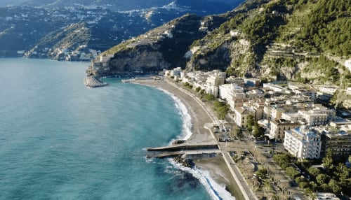 La costa turchese di Maiori con edifici a picco e spiaggia, vista aerea della struttura Casa Mannini B&B