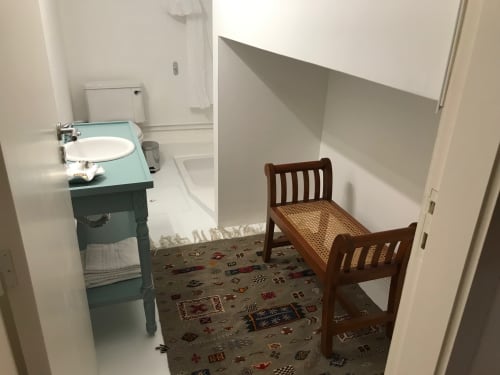 Quarto do hotel PortoSense Porto com pia vintage, cama de madeira e carpete estampado