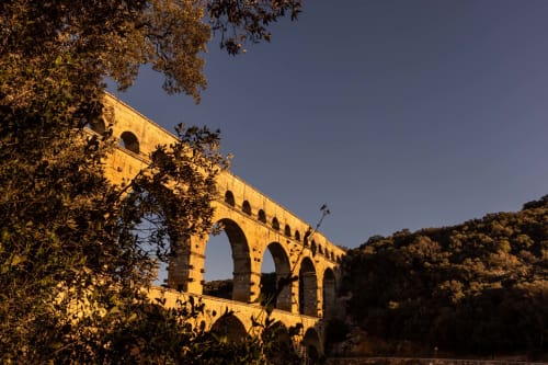 Ancient Roman aqueduct Pont du Gard illuminated at dusk near Le Prieuré Notre-Dame B&B in Montfrin, France