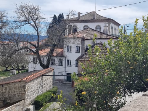 Hotel histórico Casa Do Refúgio com fachada branca e telhado em barro em Covilhã, Portugal, cercado por jardins