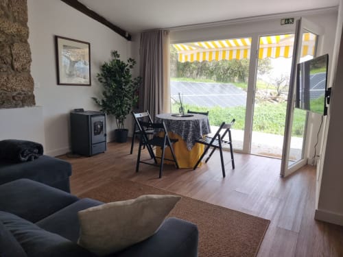 Espaço de estar moderno na Casa Do Refúgio com zona de refeições, mobiliário confortável e terraço com vista para painéis solares, Covilhã