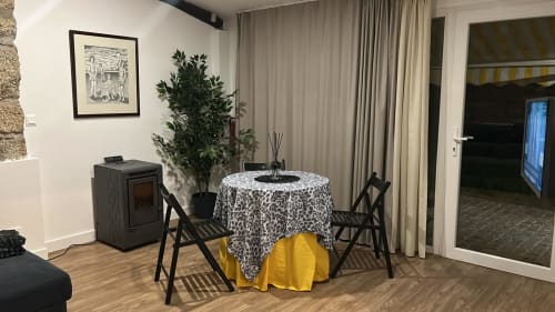Lounge moderno do Casa Do Refúgio com mesa redonda, cadeiras pretas, lareira e plantas em Covilhã