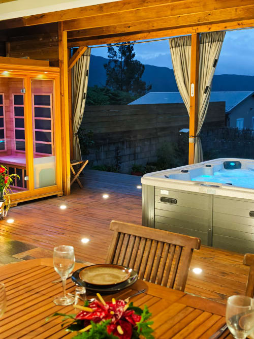 Terrasse de luxe à La Kaz 57 avec bain à remous, sauna, table à manger et vue sur le lac au crépuscule à La Plaine des Palmistes, Réunion