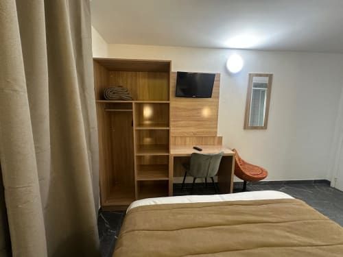 Hôtel Norotel Brumath triple room with bed, wooden shelving, desk, TV, and modern amenities