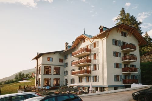 Hotel De La Sage, une charmante maison d'hôtes alpine avec balcons en bois et murs blancs en Suisse