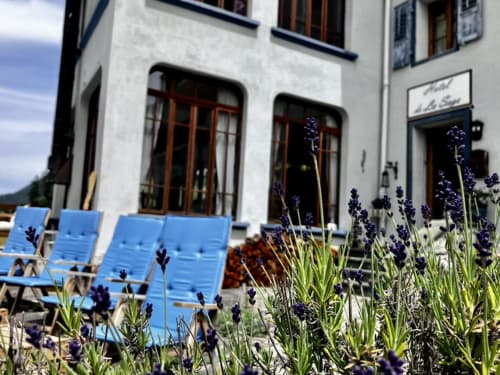 Patio de l'Hôtel De La Sage avec transats bleus et fleurs de lavande, décor alpin suisse