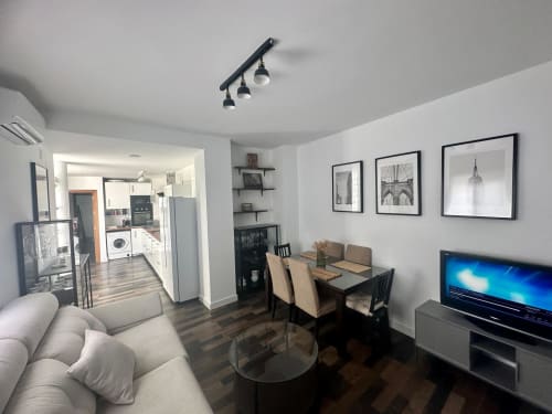 Apartamento Living Sur en Sanlúcar de Barrameda con cocina moderna, mesa de comedor y sala de estar con televisión